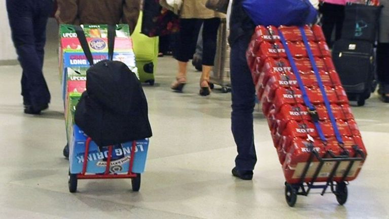 Laatikoittain alkoholia satamaan saapuvien matkustajien kärryissä.