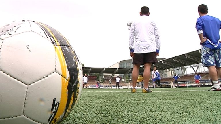 Jalkapallo ja pelaajia Töölön jalkapallostadionilla.