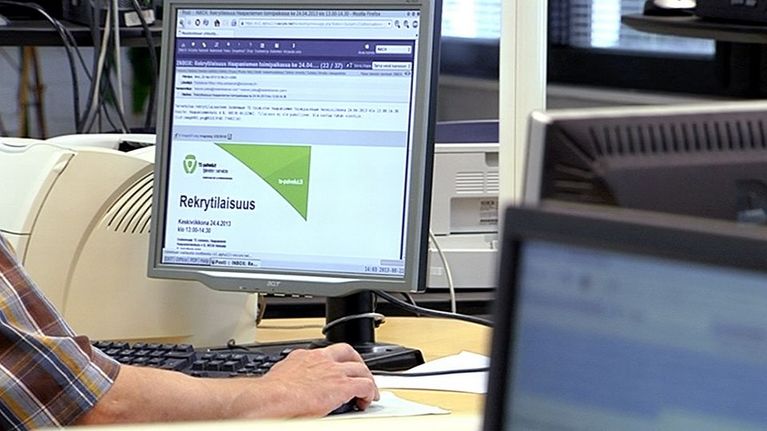 Henkilö etsimässä töitä tietokoneella.