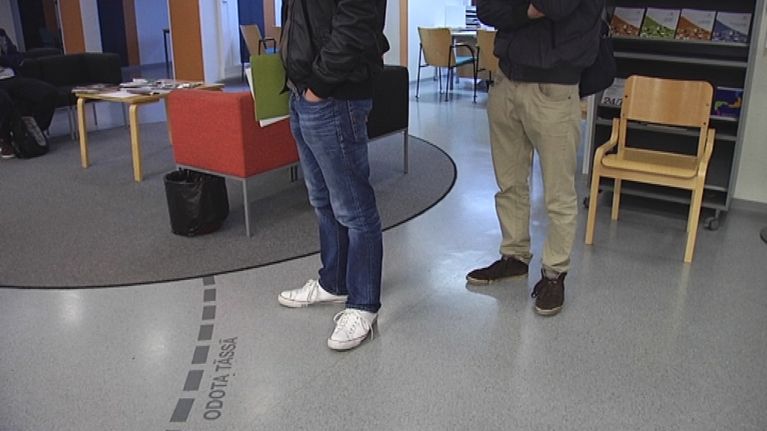 Kaksi ihmistä jonottaa te-palveluita toimistolla