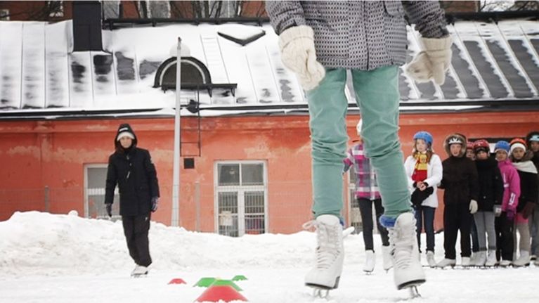 Koululaiset luistelevat koulun liikuntatunnilla.