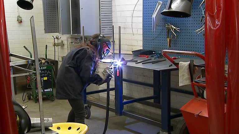 Opiskelija Aalto-yliopiston Taiteiden ja suunnittelun korkeakoulun metallityöpajassa.
