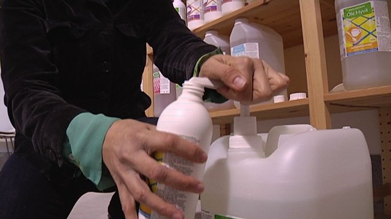 Käsi pumppaa pesuainetta pulloon