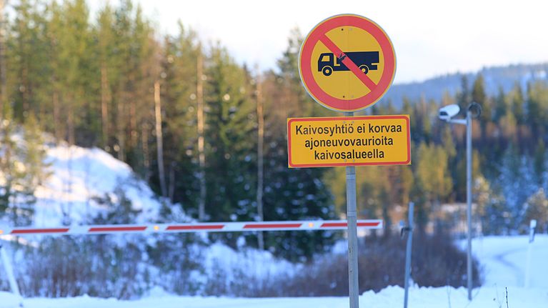 Kaivosportilla kyltti, jonka mukaan Talvivaara ei korvaa ajoneuvovahinkoja kaivosalueella