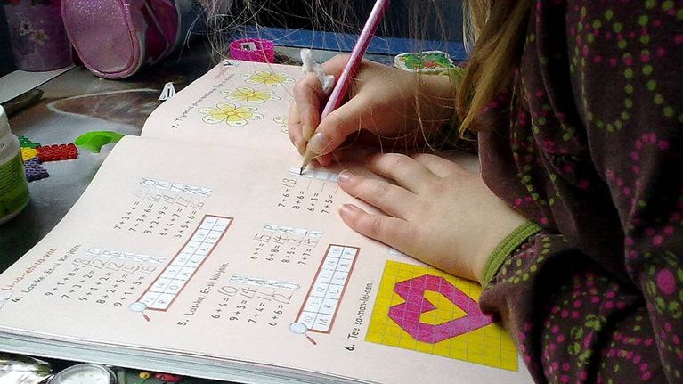 Koululainen tekee matematiikan tehtävää.