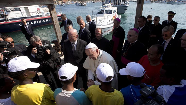 Paavi Franciscus tervehtii siirtolaisia vieraillessaan Lampedusan saarella.