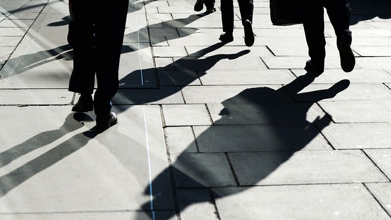 jalankulkijoiden varjoja kadulla