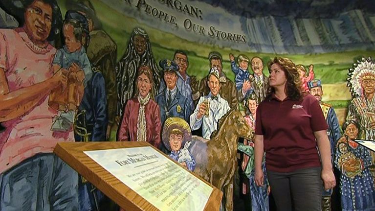 Maahanmuuttajien parissa työskentelevän One Morgan County -järjestön johtaja Brenda Zion katselee Fort Morganin museossa kaupungin historiaa kuvaavaa seinämaalausta, johon lisättiin somalinainen kuvaamaan yhteisön muutosta.