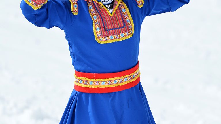 Tanja Poutiainen heiluttaa lapinpuvussa.