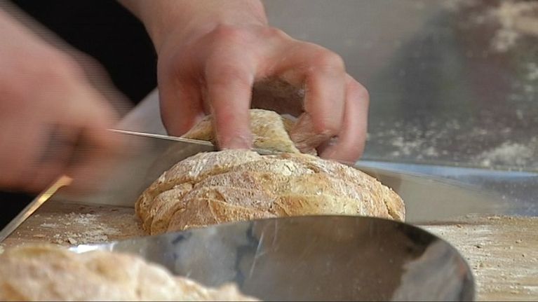 Kokki leikkaa leipää.