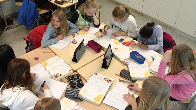 Oppilaat tekevät tehtäviä koululuokassa.