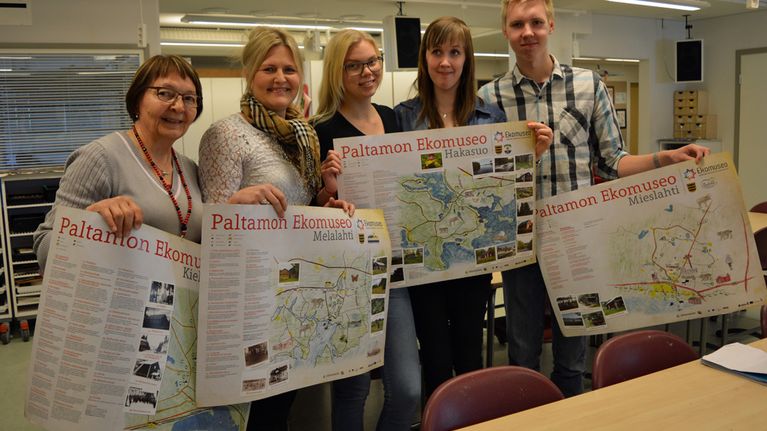 Terttu Väisänen, Pia Väisänen, Hanna Karppinen, Annukka Heikkinen ja Tomi Kemppainen kuvisluokassa perinnekartat käsissään.