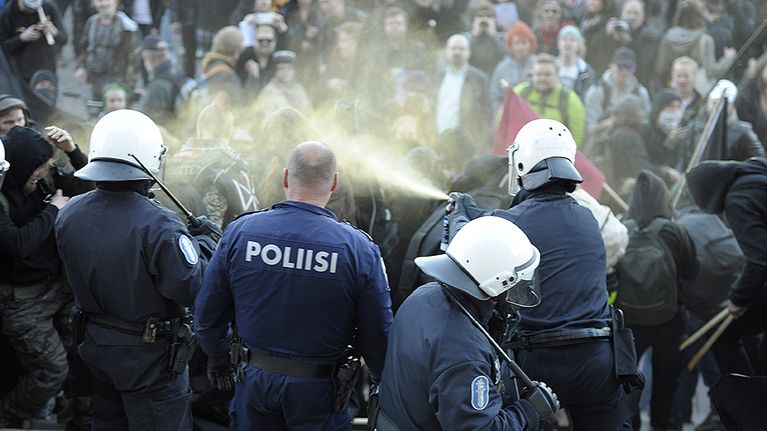 Poliisi käyttää kaasua mielenosoittajiin eduskuntalon portailla.