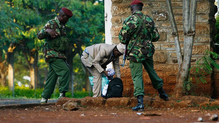 Kenialaispoliisit tarkastavat somalimiehen omaisuutta. Kuva on huhtikuulta 2014.
