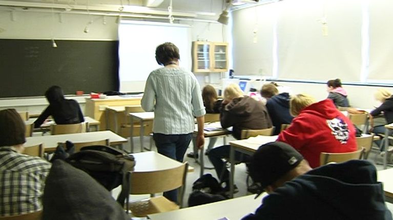 Opettaja kävelee luokassa.