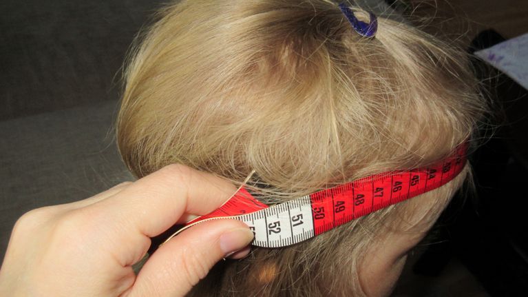 lapsen päänympäryksen mittausta mittanauhalla