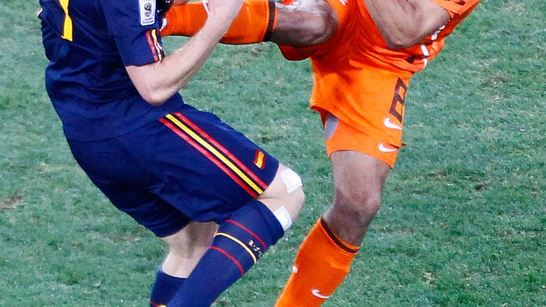 Hollannin Nigel de Jong (oik.) potkaisee Espanjan Xabi Alonsoa (vas.) rintaan.
