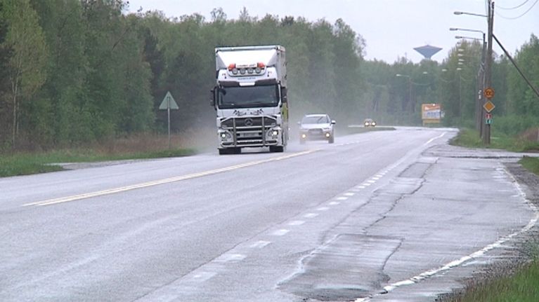 Kuvassa rekka-auto ajaa sateisella maantiellä