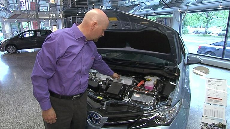  Itäkeskuksen Toyotan myyntipäällikkö Kimmo Elo esittelemässä hybiridi-Toyotan moottoritilaa, jossa ovat sekä perinteinen polttomottori että sähkömoottori.