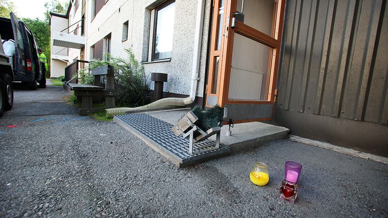 Kynttilöitä oven edessä.