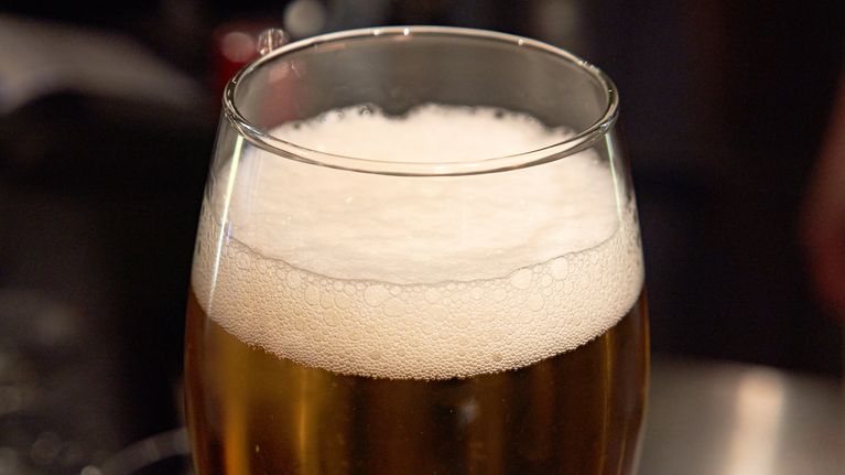 A foaming glass of beer.