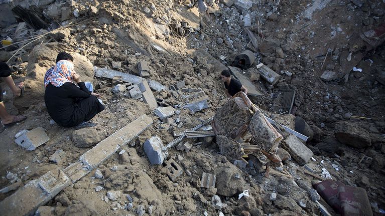 Palestiinalaismies kerää tavaroitaan Israelin ilmaiskussa tuhoutuneesta kodistaan Beit Hanussa, Gazassa 9. heinäkuuta 2014. 