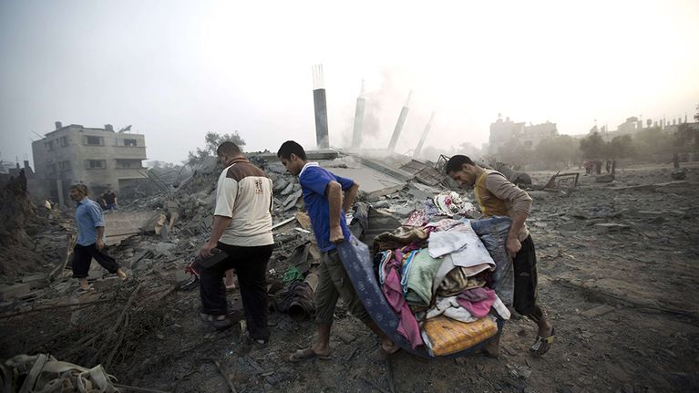 Palestiinalaiset keräsivät tavaroitaan Israelin ilmaiskussa tuhotuista kodeistaan Gazassa 8. heinäkuuta 2014. 