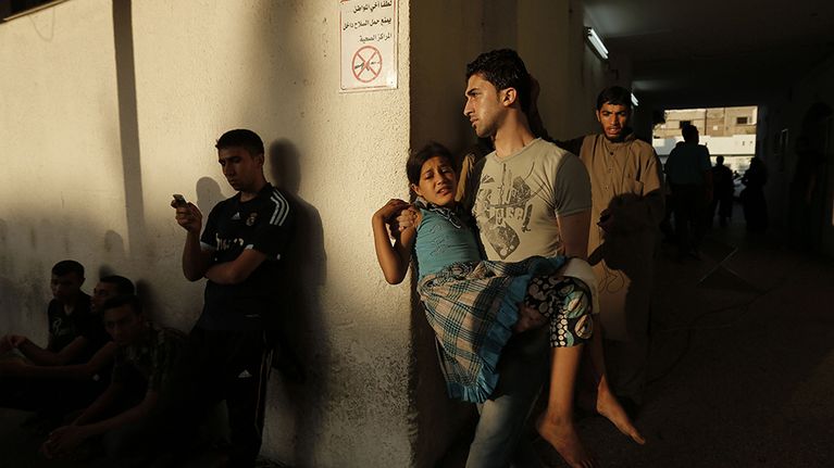 Palestiinalaismies kantoi Israelin joukkojen pommituksessa loukkaantunutta tytärtään Kamal Edwanin sairaalassa 30. heinäkuuta.