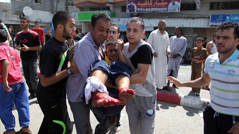Palestiinalaiset kantoivat Israelin ilmaiskussa haavoittunutta miestä ensiapuun Rafahissa sunnuntaina.