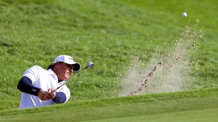 Golfari Phil Mickelson lyö pallon hiekkaesteestä.