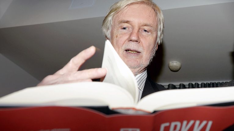 Erkki Tuomioja selaa Siinä syntyy vielä rumihia -teostaan.