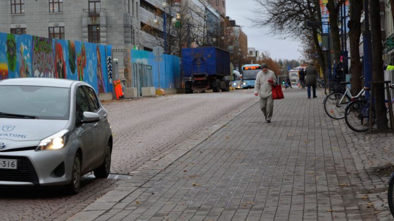 Auto, bussi ja jalankulkija Lahden Aleksanterinkadulla.