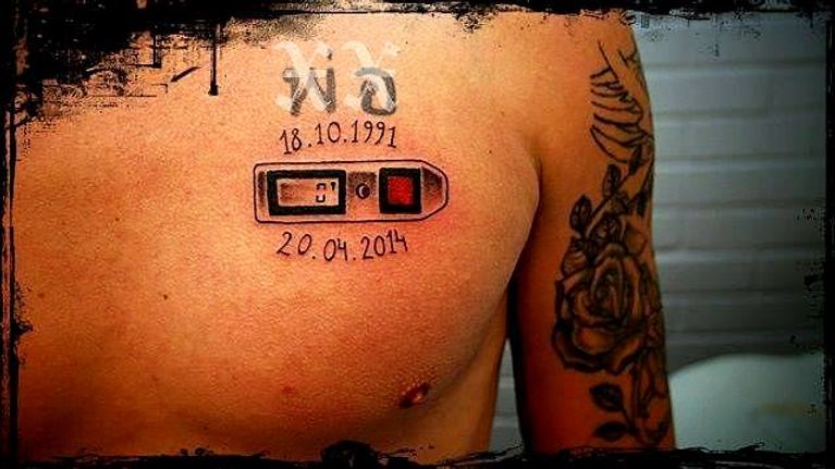 Automaattilaukaisin ja päivämäärät 18.10.1991 ja 20.04.2014 tatuoituna rintaan