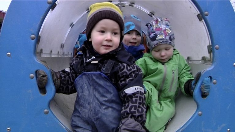 Päiväkotilapset leikkikentän liukumäessä
