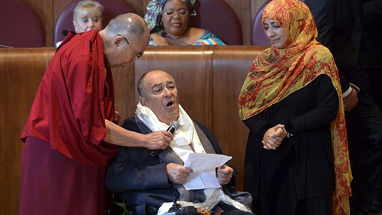 Elokuvaohjaaja Bernardo Bertolucci piti puhettaan Dalai-laman pitäessä mikrofonia ohjaajan rinnan päällä. Oikealla jemeniläinen toimittaja, poliitikko ja ihmisoikeusaktivisti Tawakkul Karman.