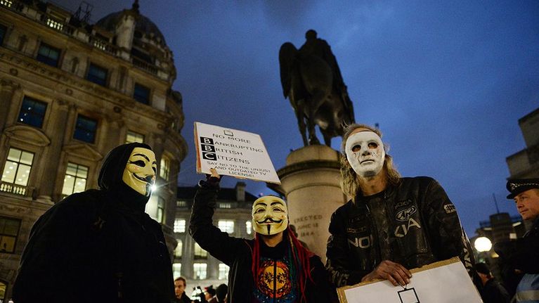 Anonymous-ryhmään kuuluviksi esiintyviä henkilöitä mielenosoituksessa Lontoossa.