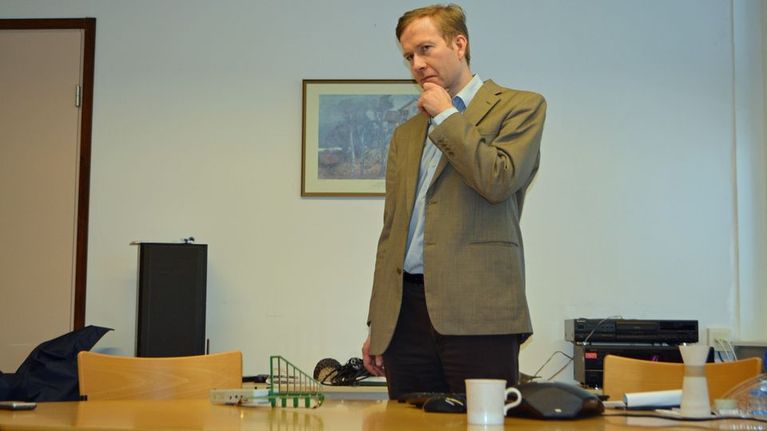 Tutkija Mikko Ahonen seisoo pöydän takana