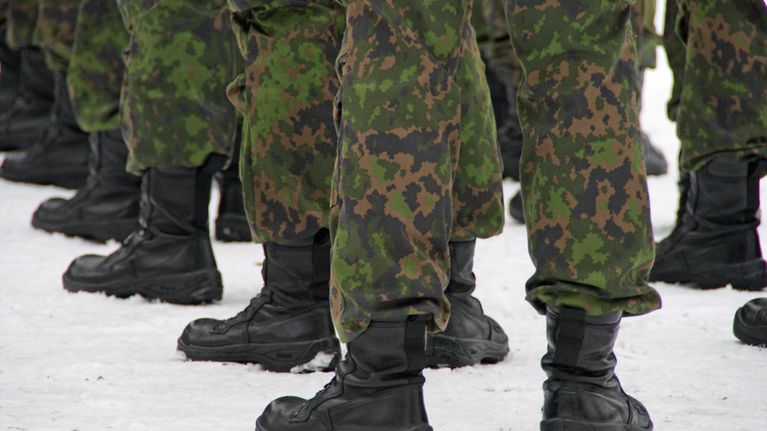 Varusmiesten jalkoja rivissä.