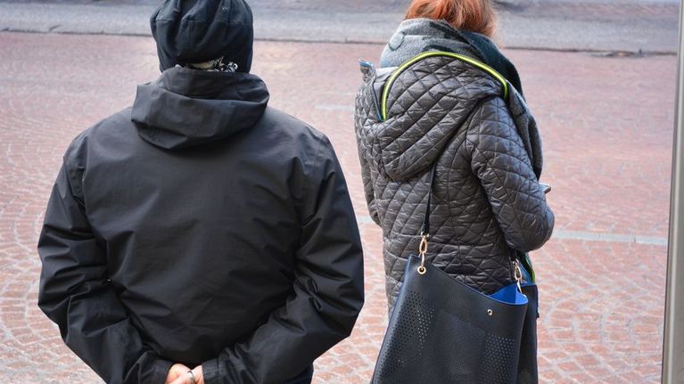 Mies ja nainen odottamassa bussia.