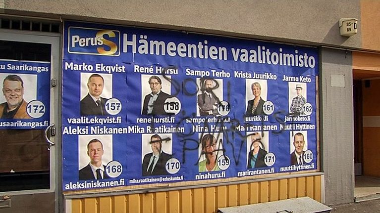 Töhrityt vaalimainokset ikkunassa.