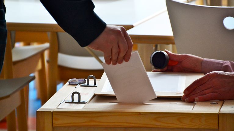 Äänestyslappu pudotetaan uurnaan.