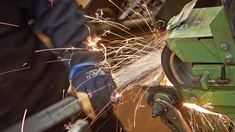 Mies työskentelee metallipajalla.