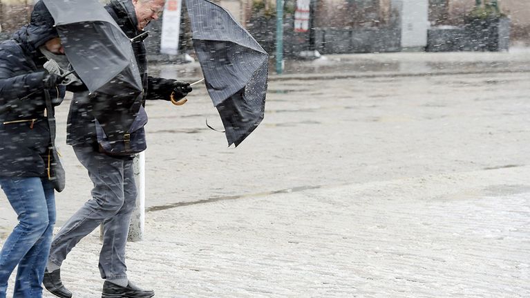 Kuvassa jalankulkijoita lumisateessa Helsingissä 30. maaliskuuta.