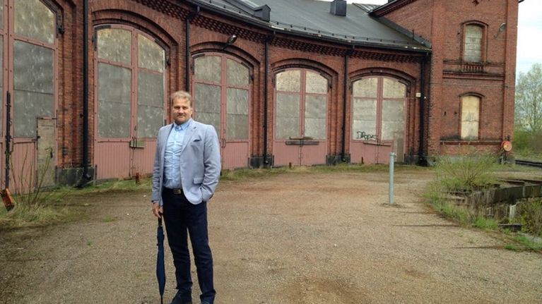 Ari Tuhkanen seisoo Mytäjäisten vanhan veturitallin edessä