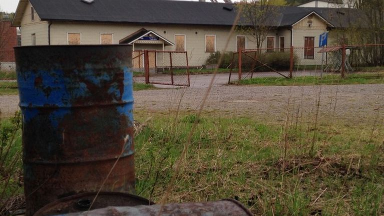 Vanha rakennus, jossa on vanerit ikkunoissa 