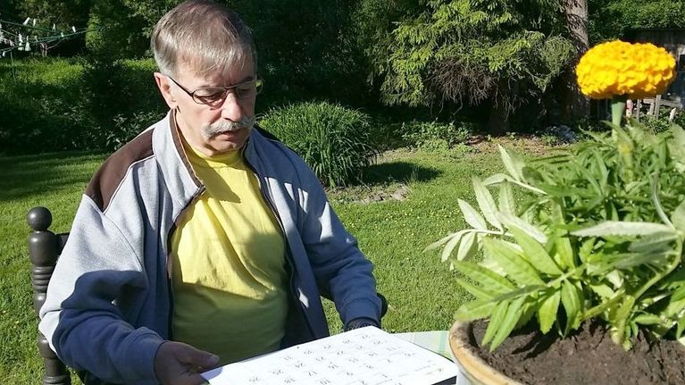 sääprofeetta Pentti Sjöblom katselee kalenteria takapihallaan