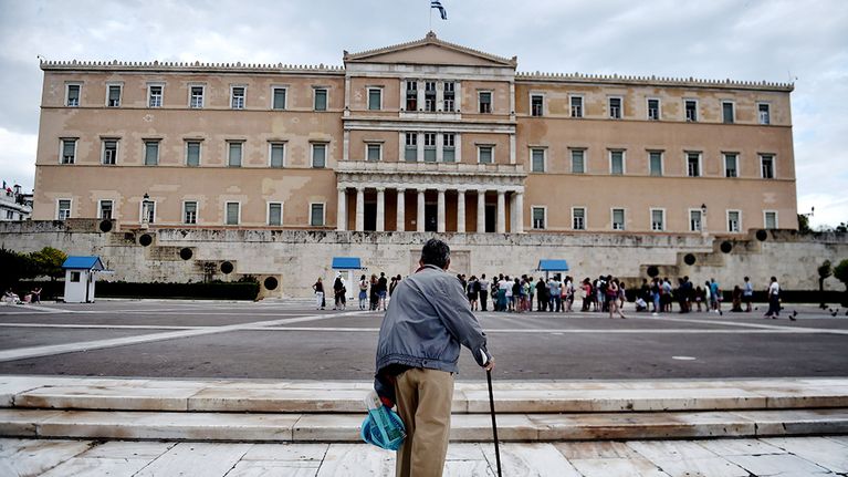 Vanha mies seisoo Kreikan parlamentin edustalla Ateenassa 27. kesäkuuta 2015.