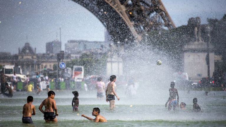 Ennätyshelteet koettelivat pariisilaisia kesäkuun lopussa. Turistit ja kaupunkilaiset vilvoittelevat Jardins du Trocadero-puistossa Eiffel-tornin juurella.
