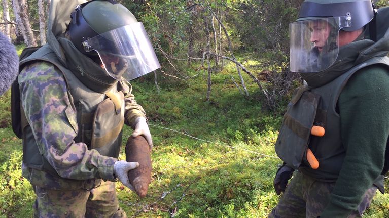 Toisen maailmansodan aikaisia Natsi-Saksan armejan räjähteitä löytyy yhä Lapista. Sodankylän Jääkräprikaatin pioneerit tarkastelevat 105 mm tykinkranaattia  14.8.2015 Pohjois-Lapissa.