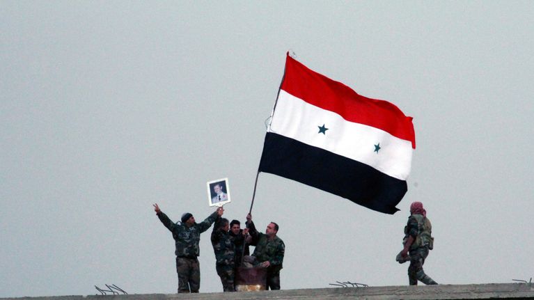 Syyrian hallituksen joukot heiluttavat Syyrian lippua. 
